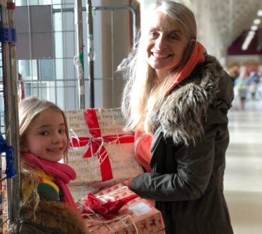 Little girl and her mother are giving donation boxes to a charity for christmas.